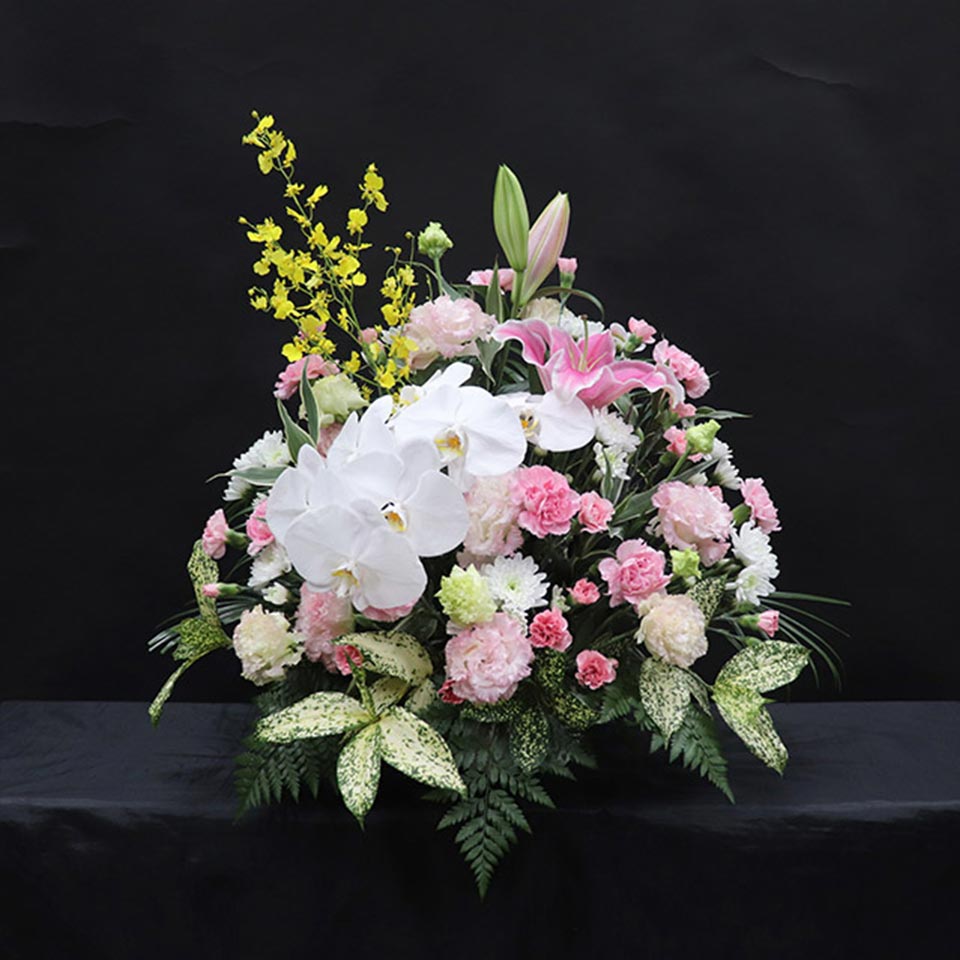 白い胡蝶蘭にピンクのカーネーションなどを組み合わせた枕花