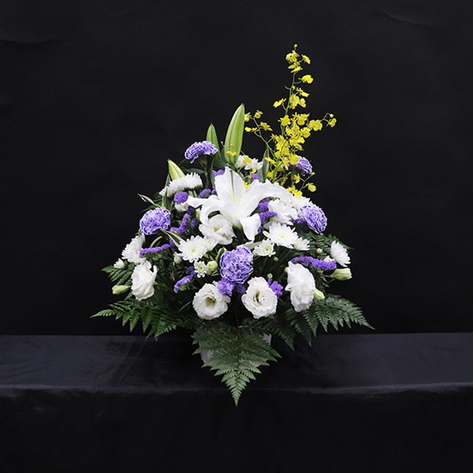 白いユリと紫と白の花で彩られた枕花